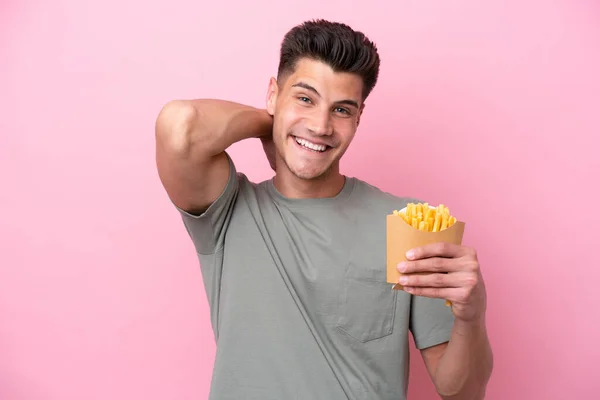 Jonge Kaukasische Man Met Gebakken Chips Geïsoleerd Roze Achtergrond Lachen — Stockfoto
