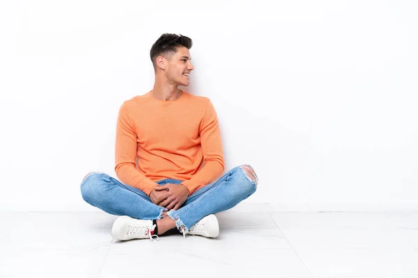 Genç Adam Beyaz Arka Planda Izole Bir Şekilde Yerde Oturuyor — Stok fotoğraf