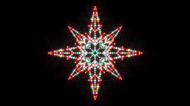 A slow colour changing looped illuminated animation video of a Christmas star shape made with real LED Christmas lights and filter added to imitate a stage screen style background.