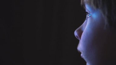 karanlık bir odada bir çizgi film izlerken genç çocuk