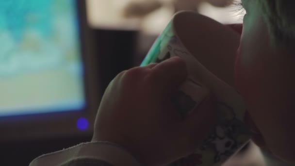 Jonge jongen kijken cartoons in een donkere kamer op een computer — Stockvideo