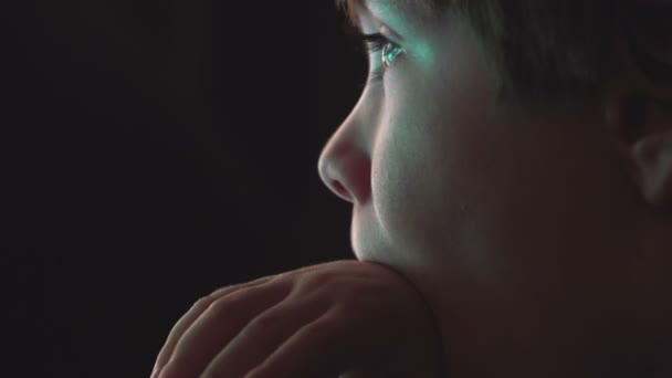 Kleiner Junge schaut Zeichentrickfilme in einem dunklen Raum auf einem Computer — Stockvideo