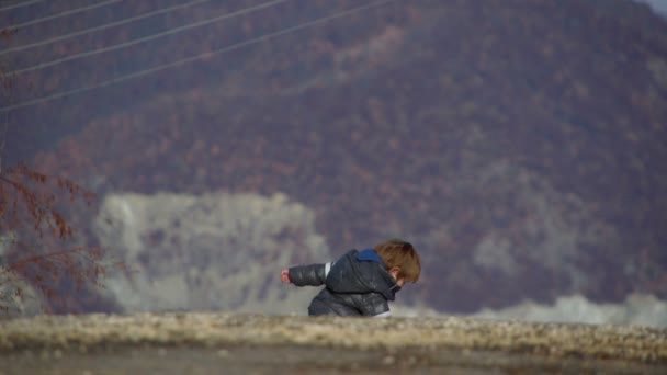Sony fs-100 - mladý chlapec hrát venku v zimním období. — Stock video