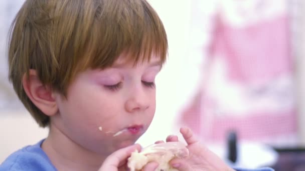 Jeune garçon manger un sandwich pour le petit déjeuner 