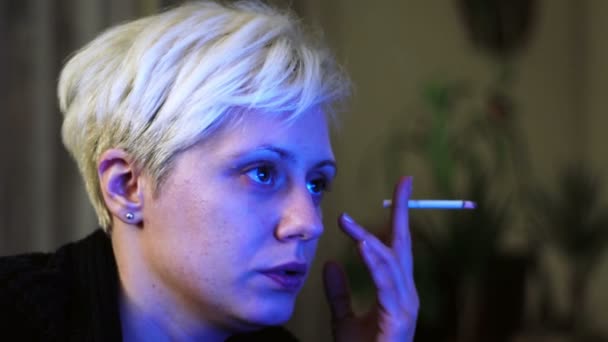 Super 35mm kamera - ung, blond haired kvinna arbetar sent på natten och röka en cigarett — Stockvideo