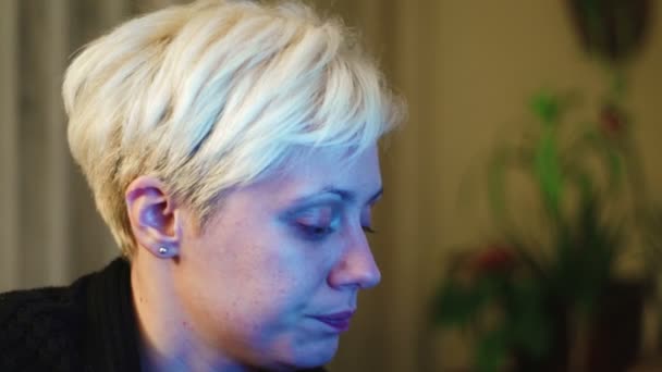 Super 35mm camera - jonge, blond haired vrouw werken laat op de avond van haar woonkamer en roken — Stockvideo
