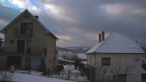 Hermosas y rápidas nubes que se mueven sobre las casas del pueblo en invierno — Vídeos de Stock