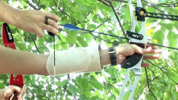 Young man shooting with bow and arrows (logos removed) — Stockvideo
