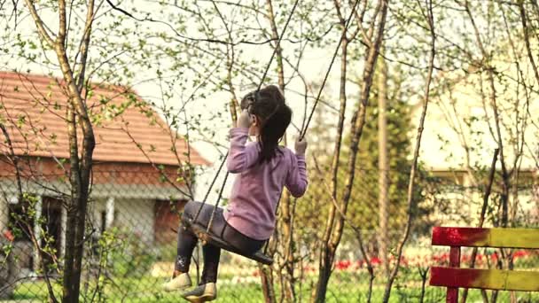 Девушка качается на веревке качели в природе — стоковое видео