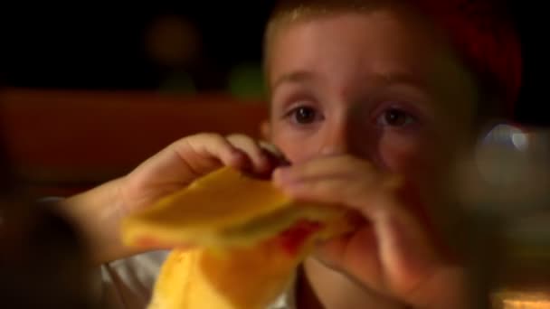 Young boy eating sandwich at night — Stock videók