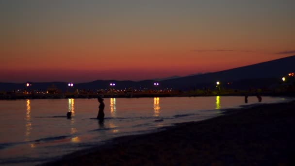 Cámara Super 35mm - tranquila puesta de sol en la playa en Grecia con dos mujeres nadando — Vídeos de Stock