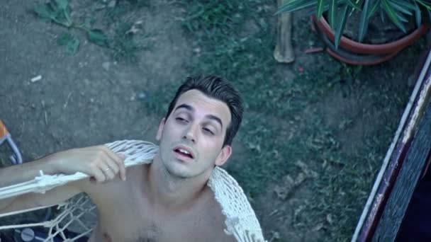 Пьяный мужчина спит в гамаке на открытом воздухе — стоковое видео