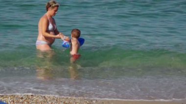 Women and boy at the beach and in the sea