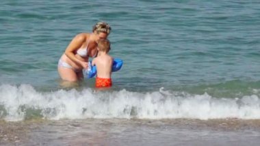 Women and boy at the beach and in the sea