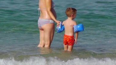 Women and boy at the beach and in the sea
