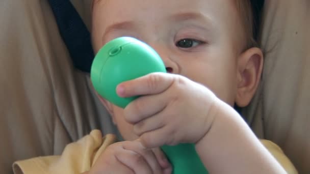 Lindo bebé jugando con un teléfono de plástico verde — Vídeos de Stock