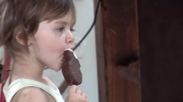 Carino ragazza dagli occhi azzurri leccare un gelato — Video Stock