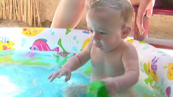 Little boy playing in the pool. Splashing and hitting the water — 비디오