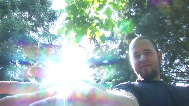 Чоловік відкриває руку, щоб показати сонце в ньому — стокове відео