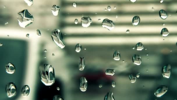 Regentropfen rutschen die Fensterscheibe herunter — Stockvideo