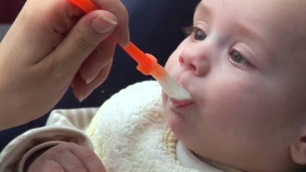 Baby isst und lächelt — Stockvideo