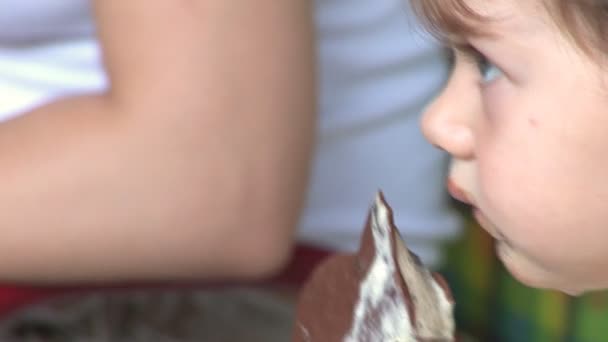 Mignon fille aux yeux bleus lécher une glace — Video