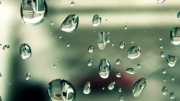 Σταγόνες βροχής συρόμενη κάτω από το γυαλί παράθυρο — Αρχείο Βίντεο