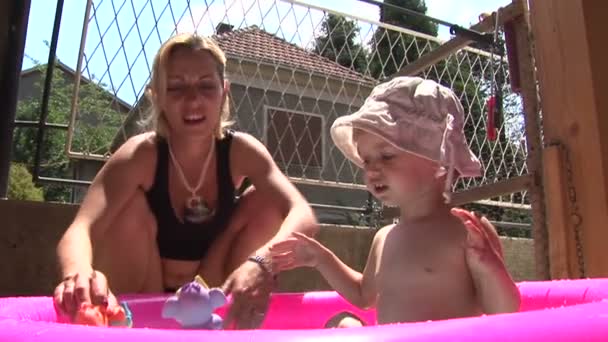 Mamá y su hija jugando en una pequeña piscina — Vídeos de Stock