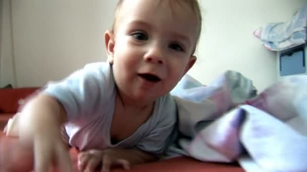 Baby op bed camera kijken — Stockvideo