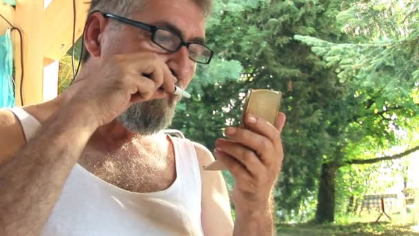 Bebaarde man trimmen zijn snor — Stockvideo
