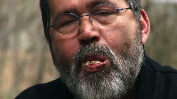 Senior bearded man with glasses eating bread — 비디오