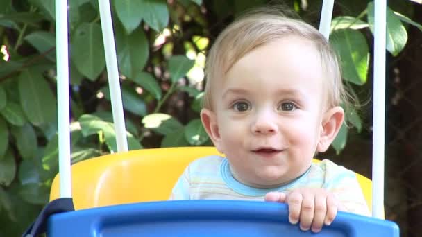 Kleine babyjongen swingende buitenshuis — Stockvideo