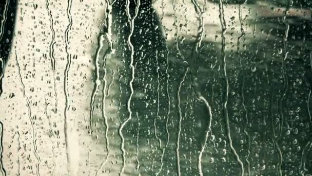 Regentropfen rutschen die Fensterscheibe herunter