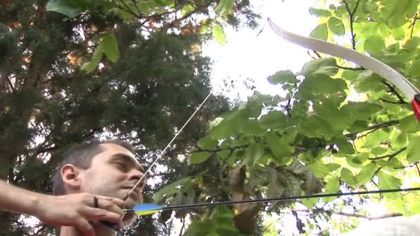 Mladý muž trénovat lukostřelbu v přírodě — Stock video