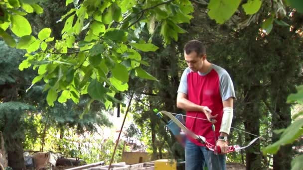 Ung man öva bågskytte i naturen — Stockvideo