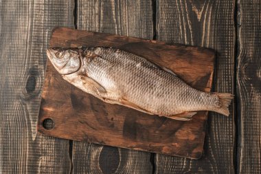 Koyu ahşap bir masada kurutulmuş balık, bira atıştırmalıkları..