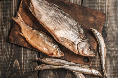 Koyu ahşap bir masada kurutulmuş balık, bira atıştırmalıkları..