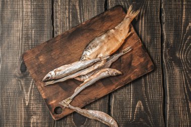 Koyu ahşap bir masada kurutulmuş balık, bira atıştırmalıkları..