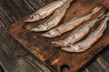 Koyu ahşap bir masada kurutulmuş balık, bira atıştırmalıkları..