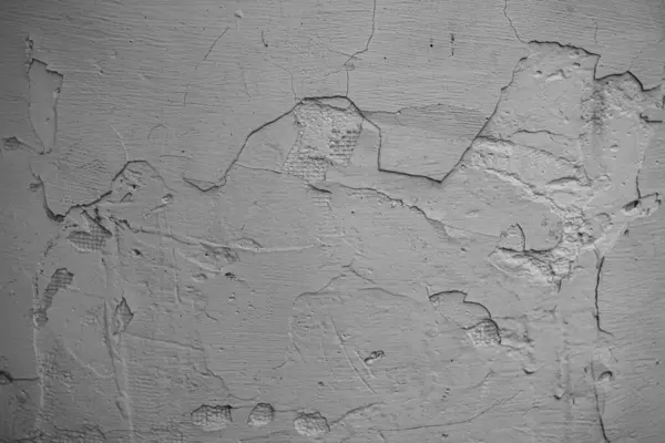 Üzerinde çatlaklar olan beyaz ve gri bir duvar. Beton ve çimento dokusu. Sıva. Grunge 'un geçmişi. Eski beton yüzey.
