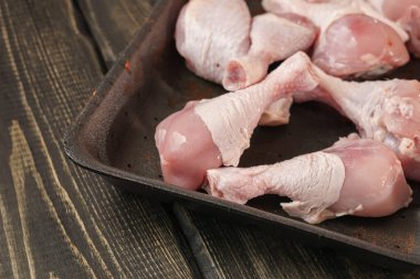 Tavuk butları ahşap bir masada. Çiğ tavuk eti..