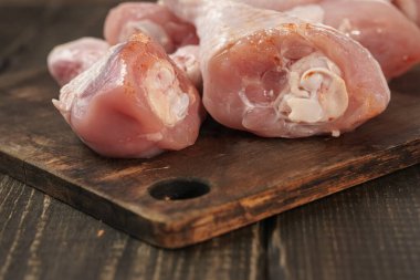Tavuk butları ahşap bir masada. Çiğ tavuk eti..