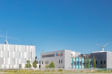 Eemshaven, Hollanda - 2 Haziran 2022: Hollanda 'nın Eemshaven kentindeki açık mavi gökyüzünün önündeki bir Google veri merkezinin giriş görüntüsü