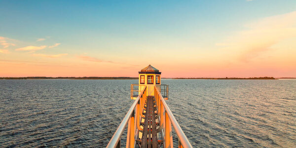 Sunset over Dutch national park Lauwersmeer in Friesland with an ancient lighthouse in front