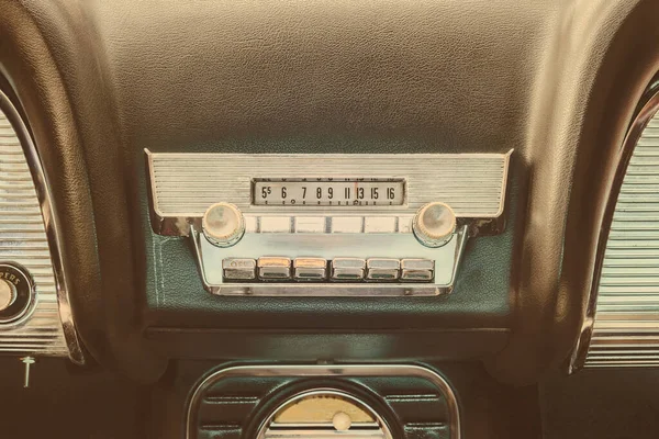 Old car radio inside a classic American car with chrome dashboard