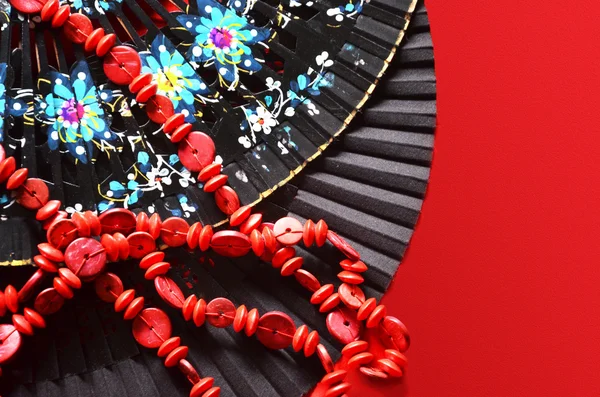 two open hand fan and red beads