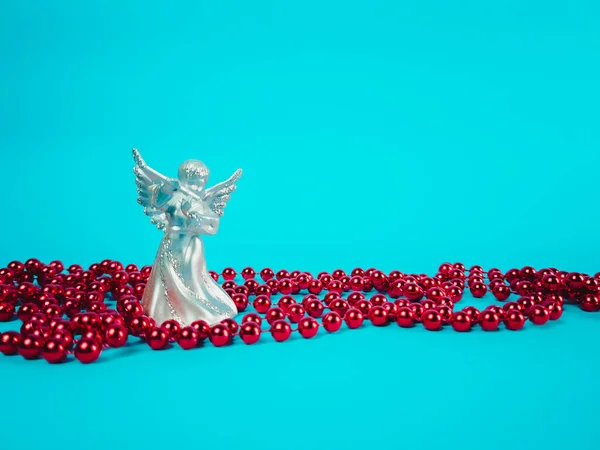 Mavi arka planda süslemeleri olan Noel meleği heykeli