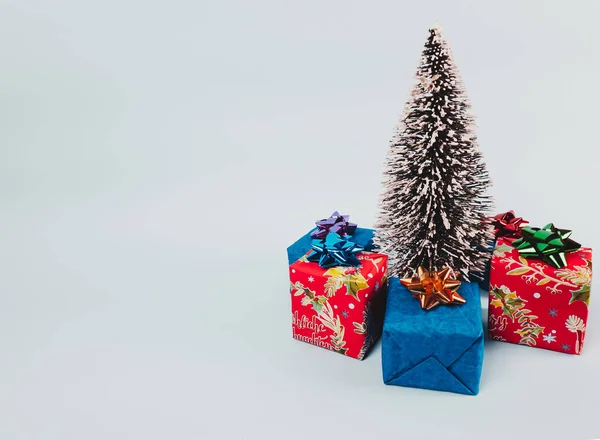 Beyaz arka planda hediyeleri olan Noel ağacı