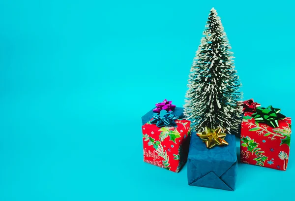 Mavi bir arka plan üzerinde hediyeler ile Noel ağacı