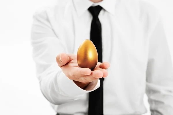 Businessman holding a golden egg — Stock Photo, Image